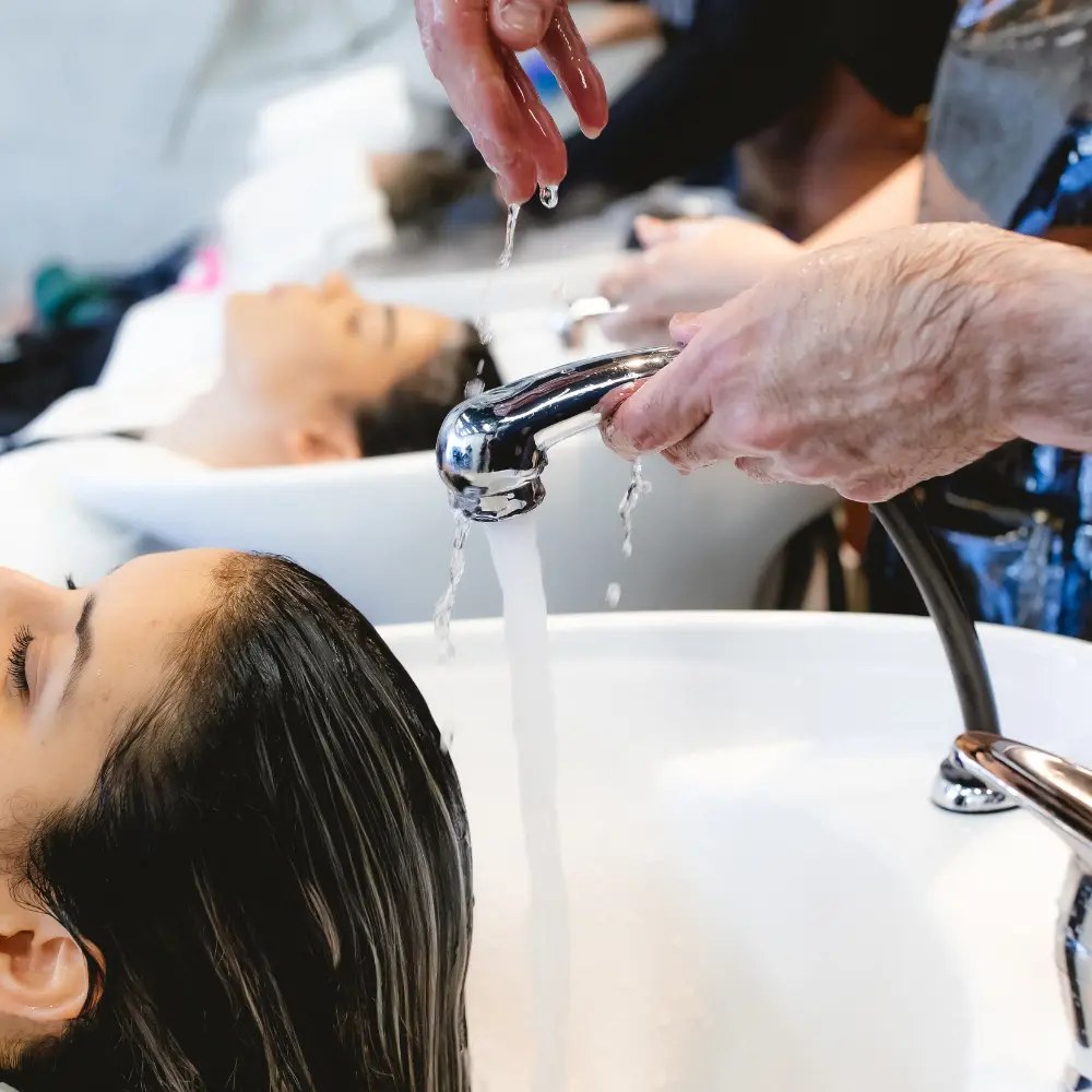 A client relaxing at the wash basin during a hair ritual at Hāste Urban Hair Spa