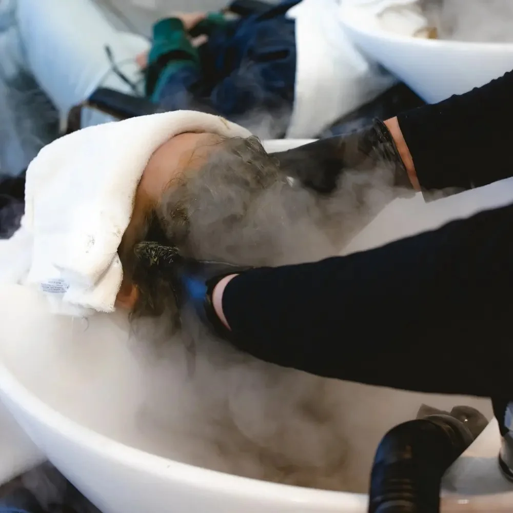 A stylist preparing a repairing hair serum at Hāste Urban Hair Spa