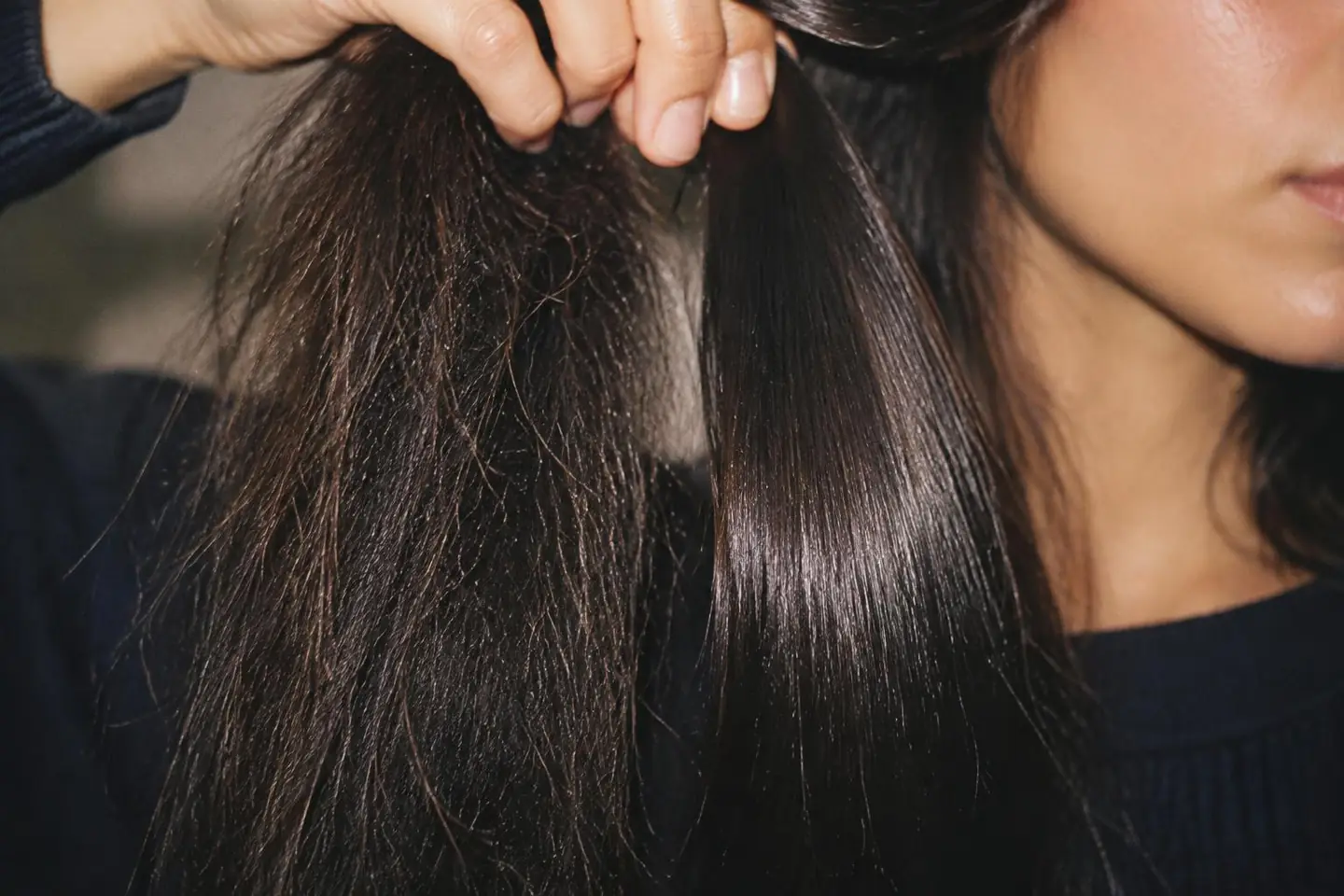Close-up comparing a frizzy section of hair with a smooth, glossy treated section