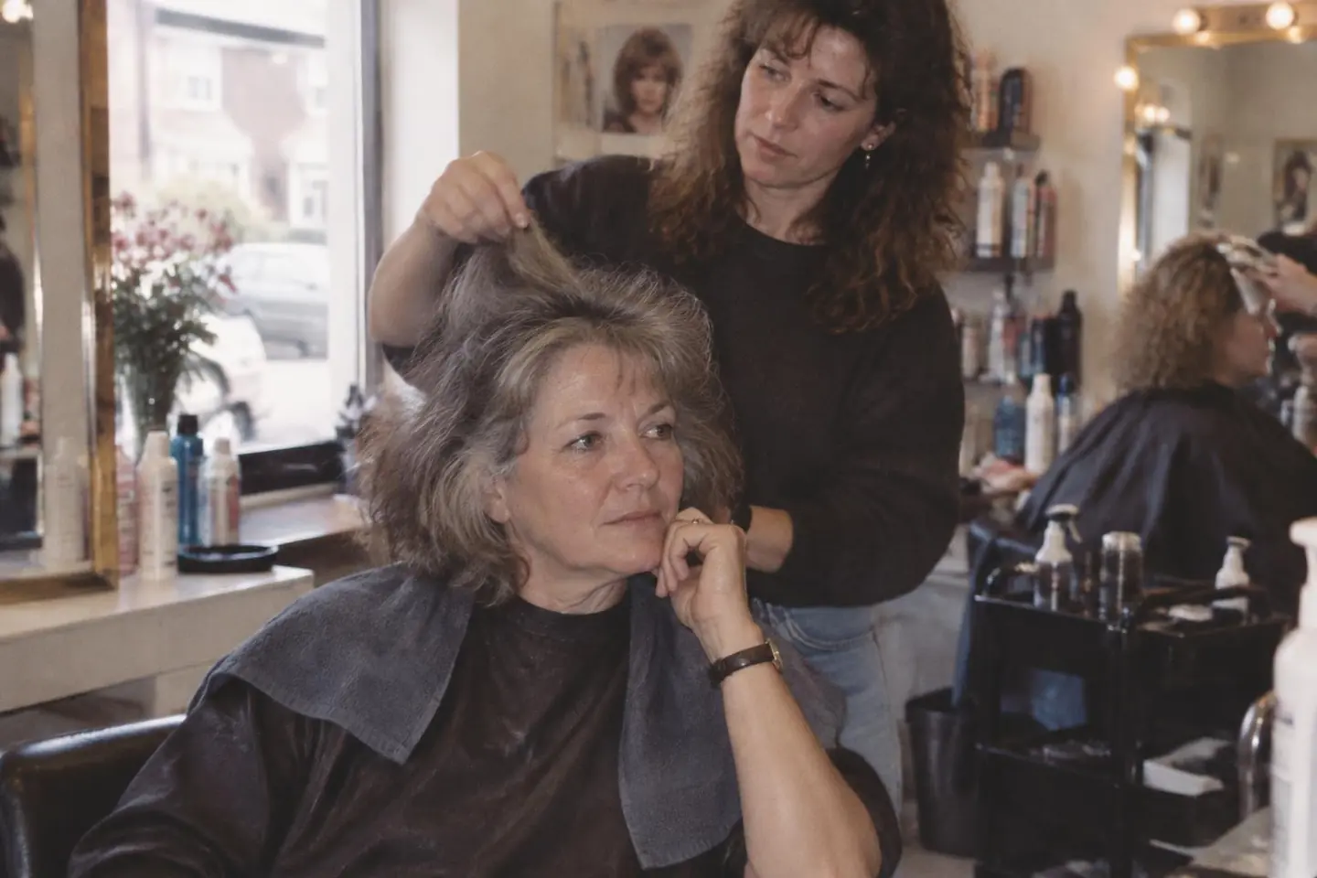 A stylist consulting with a client about her personalized hair care routine